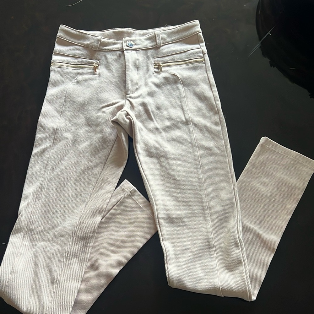 Girl’s stretch jeans with gold zipper and button detailing.